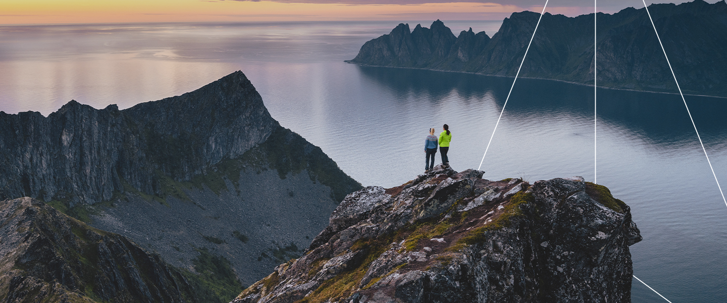 Two people on a cliff with sunset