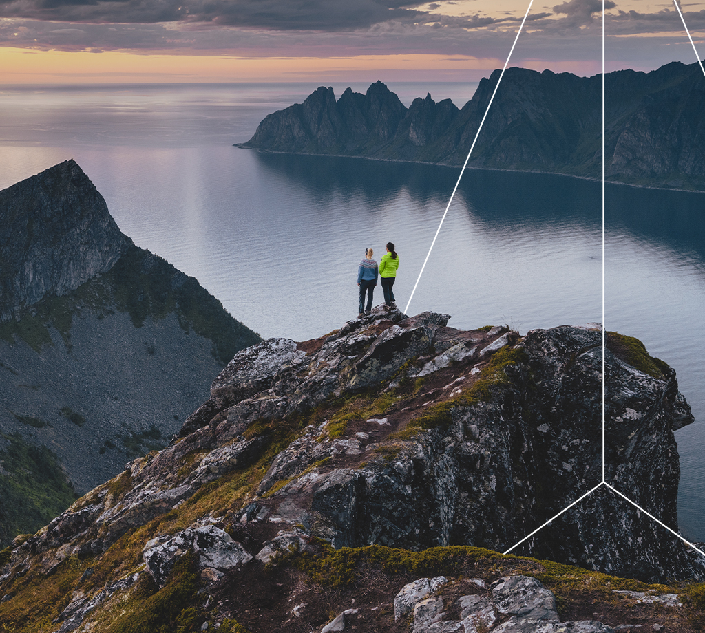 Two people on a cliff with sunset