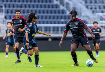 DC United Soccer player kicking ball with eagle mascot