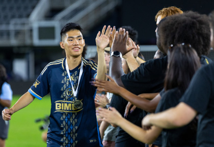 DC United Soccer player kicking ball with eagle mascot