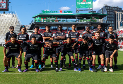 DC United Soccer player kicking ball with eagle mascot