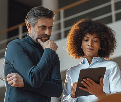 man and woman looking at ipad