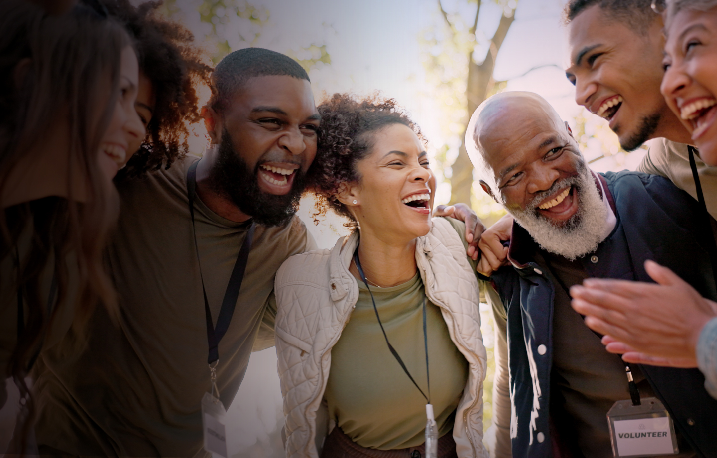 Group of people huddling and smiling 