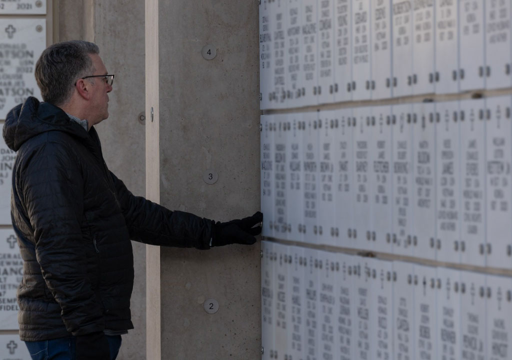 Man looking at memorial on wall