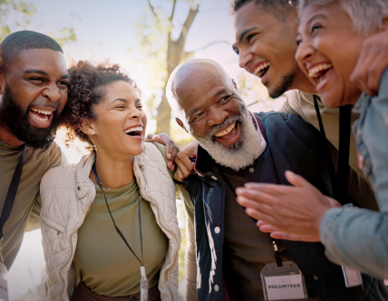 Group of people huddling and smiling 