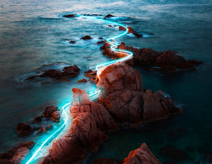 glowing path of light through rocky coastline