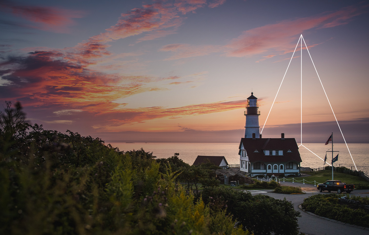 Lighthouse by cliff at sunset