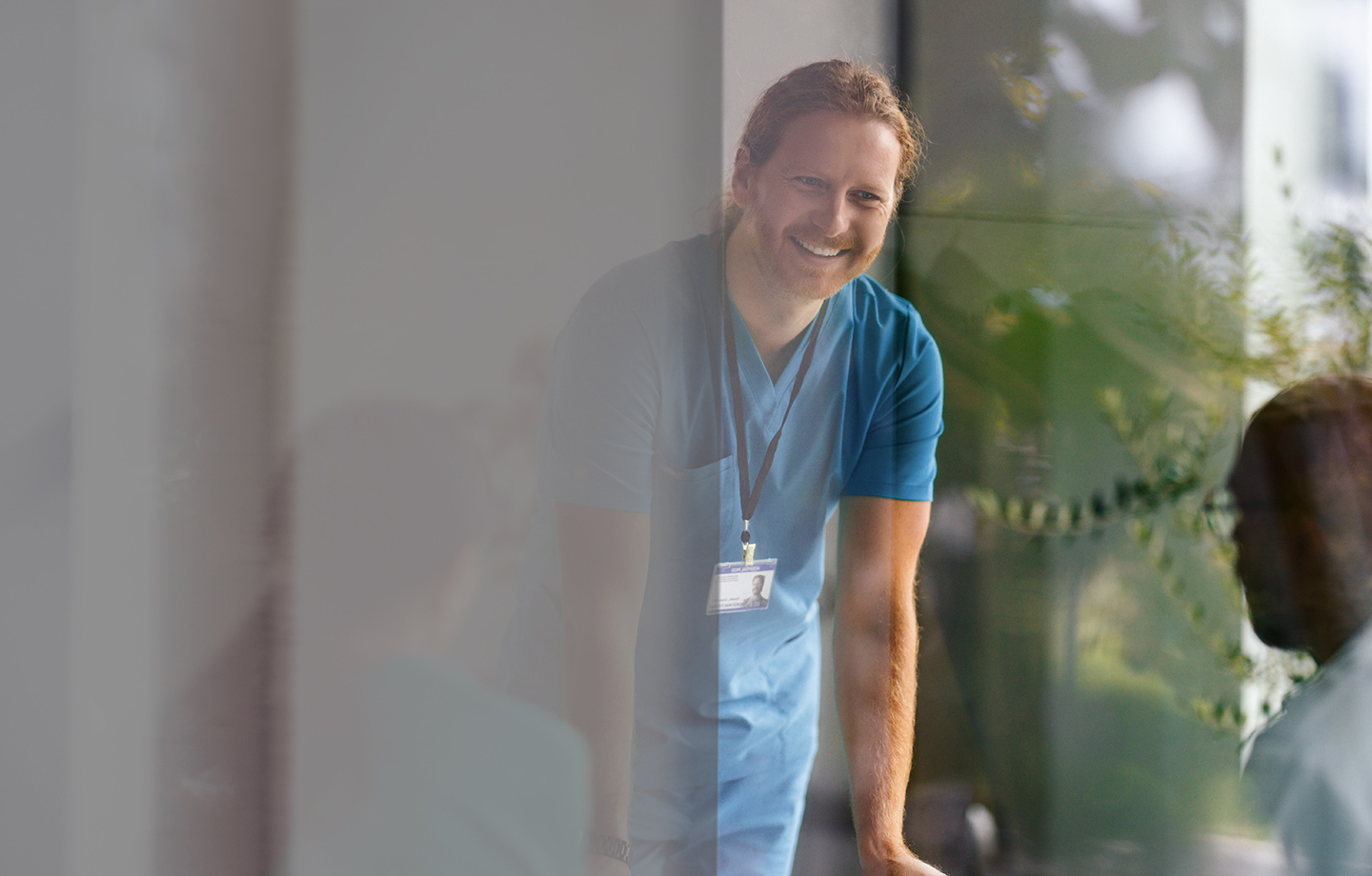 Healthcare working in blue scrubs smiling in meeting