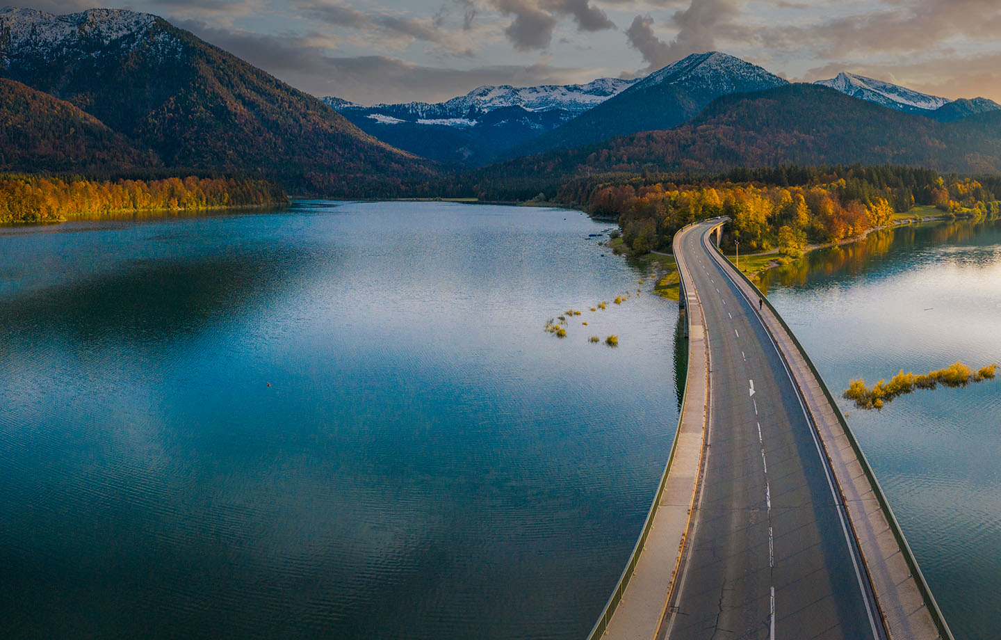 bridge road over water through mountainside in autumn 