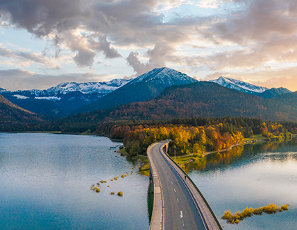 bridge road over water through mountainside in autumn 