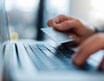 person entering credit card information on laptop