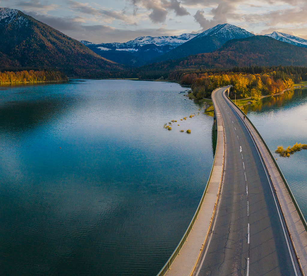 bridge road over water through mountainside in autumn 