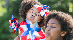 Mother and child blowing a patriotic pinwheel