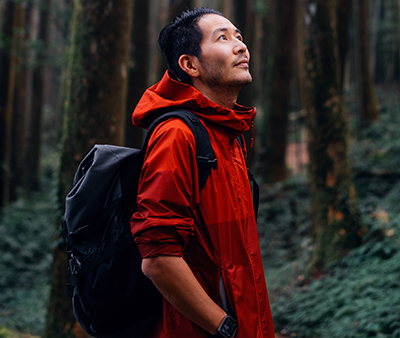 happy man in red jacket in forest