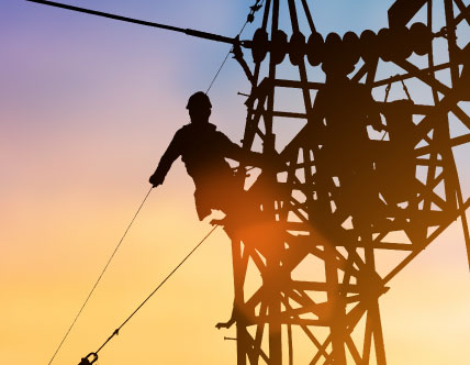 Silhouette of electrician climbing an energy tower