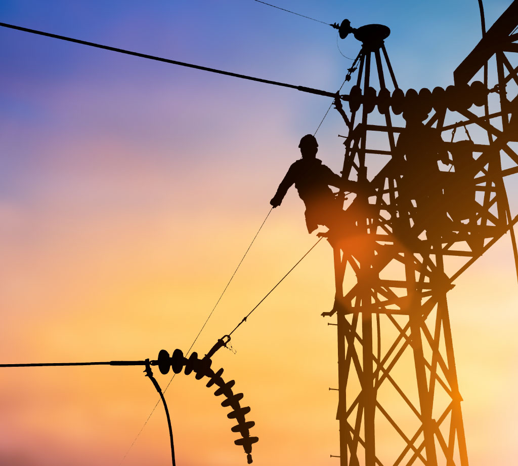 Silhouette of electrician climbing an energy tower