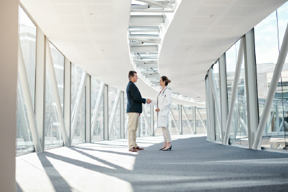 people shaking hands in light filled hallway