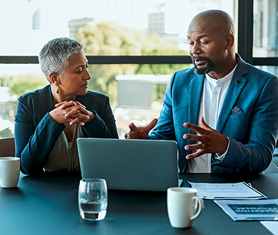 woman and man talking and a laptop