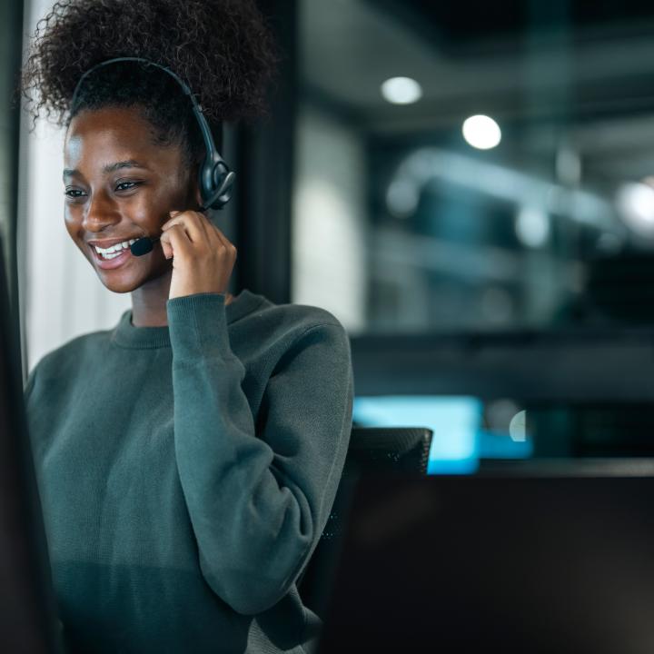 Customer service, happy and communication of woman at callcenter desktop talking with joyful smile. Consultant, advice and help desk girl speaking with clients online with computer headset mic.