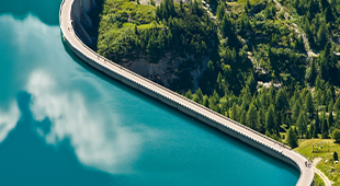 Road through blue lake and green forest