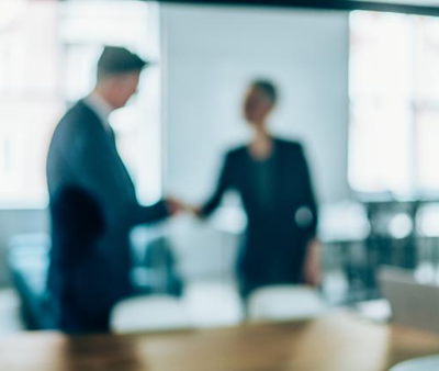 Out of focus people shaking hands
