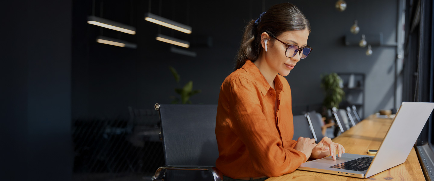 Woman at laptop with orange shirt