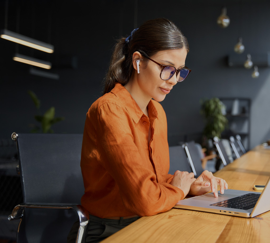 Woman at laptop with orange shirt